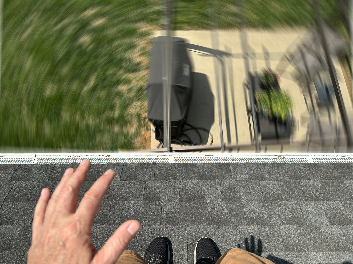 Person on the edge of a roof looking down. The ground is spinning.
