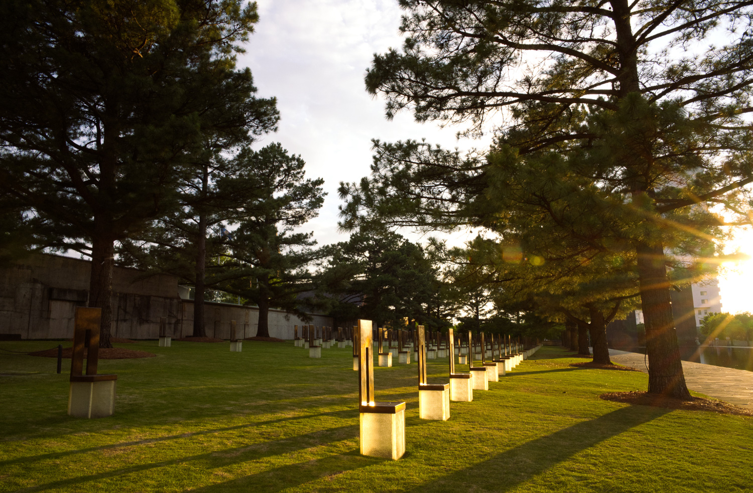A park with low sun illuminating the memorials
